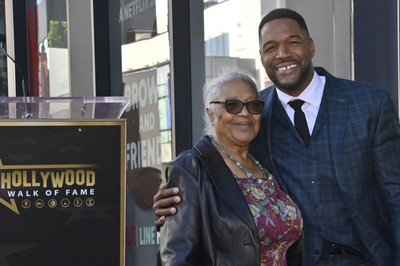 TV personality and former NFL player Michael Strahan kneels next to his star during an unveiling ceremony honoring the 2,744th star on the Hollywood Walk of Fame Monday.  Photo by Jim Ruymen/UPI