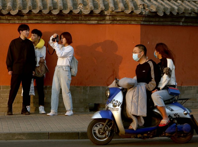 A group of Chinese film students, not wearing face masks, visit a tourist area as the threat of the deadly coronavirus fades in Beijing on Sunday. Photo by Stephen Shaver/UPI