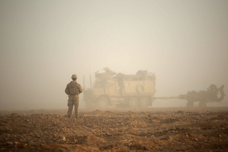 A U.S. Marine waits to guide a troop movement armored vehicle towing an M777-A2 Howitzer to a firing position in an undisclosed location in Syria on May 14. File Photo by Sgt. Matthew Callahan/U.S. Marine Corps/UPI