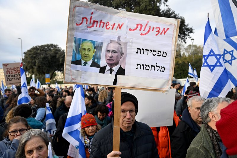 A man holds a sign at a protest calling for Israeli Prime Minister Benjamin Netanyahu to resign for abandoning the nation outside the Knesset, the parliament, in Jerusalem on January 14. Photo by Debbie Hill/UPI