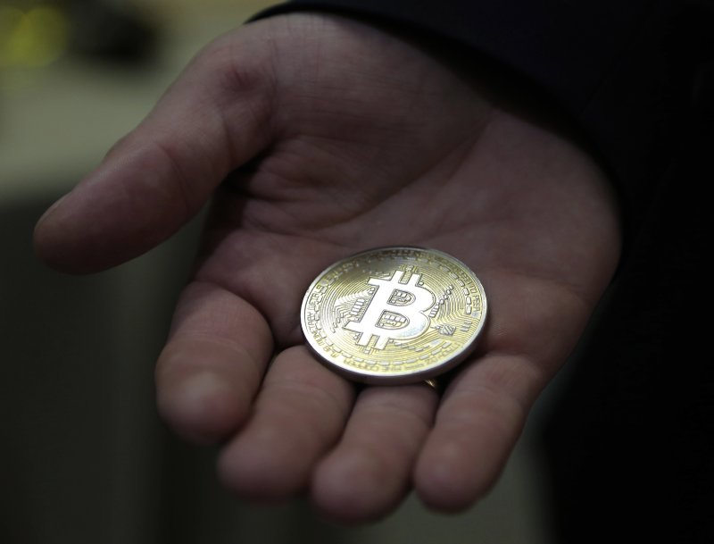 A visitor holds a souvenir Bitcoin. A blockchain analysis company said in a report that RenBridge has helped criminals launder $540 million in cryptocurrency. File Photo by Maxim Shipenkov/EPA-EFE