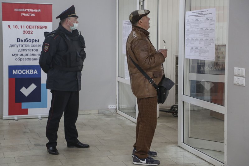 A police officer wearing a mask watched a examing a candidates list during voting at a polling station in Moscow on Friday. Photo by Maxim Shipenkov/EPA-EFE