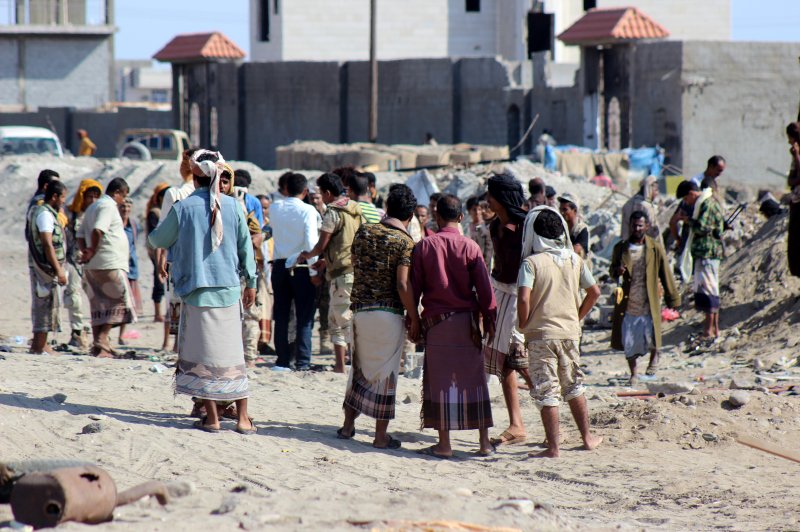 Yemeni people and soldiers stand at the site of suicide bombing December 18, 2016, near a military base in the southern province of Aden, Yemen.The U.S. military said Sunday that one service member was killed and three others wounded in a raid in Yemen targeting its local al-Qaida branch. Photo by EPA.