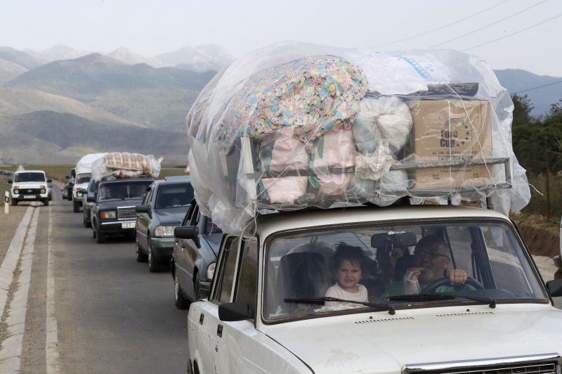 Ethnic Armenians from Nagorno-Karabakh cross the border with Azerbaijan by car, carrying their belongings with them, near the village of Kornidzor, Armenia, on Friday. Photo by Anatoly Maltsev/EPA-EFE