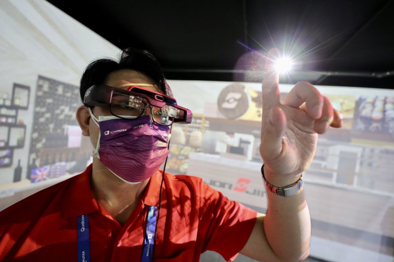 A staff member wears a mask while demonstraitnga pair of Google Metaverse virtual reality glasses during the COMPUTEX 2022 exhibition in Taipei, Taiwan, on May 24. Photo by Ritchie B. Tomgo/EPA-EFE