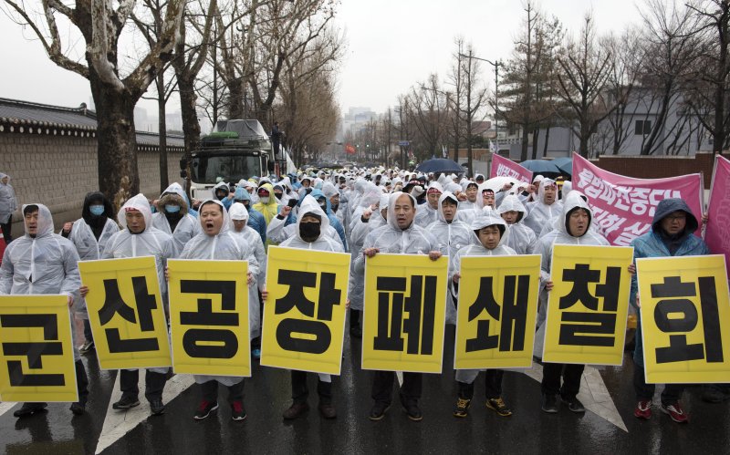 Unionized workers of GM Korea Co., the South Korean unit of General Motors Co., call for the retraction of a GM decision to close GM Korea's factory in Gunsan, during a protest held amid rain near the presidential office Cheong Wa Dae in Seoul, South Korea, 28 February 2018. On 13 February GM announced it would close the Gunsan car assembly plant, citing low productivity. Photo by Yonhap.