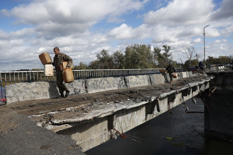 Ukrainian soldiers carry supplies across a damaged bridge into the newly liberated city of Kupiansk, east of Kharkiv, Ukraine, on Monday. The Ukrainian army pushed Russian troops from occupied territory in the northeast of the country in a counterattack. Photo by Atef Safadi/EPA-EFE