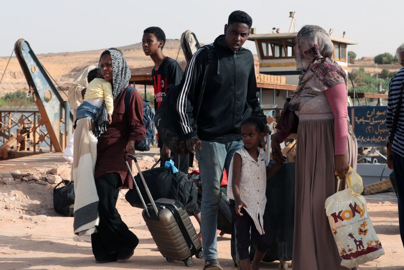 Sudanese people walk with belongings after crossing the border from Sudan to southern Egypt, on May 18. According to the UNHCR office, some 200,000 people have fled Sudan since the beginning of an armed conflict between the Sudanese military and the RSF (Rapid Support Forces) militia. Photo by Khaled Elfiqi/EPA-EFE