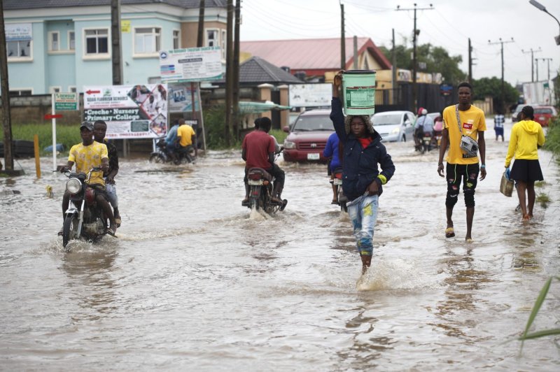 People wade through a flooded district in Lagos, Nigeria, back in September after a torrential downpour. File photo by Akintunde Akinleye/EPA-EFE