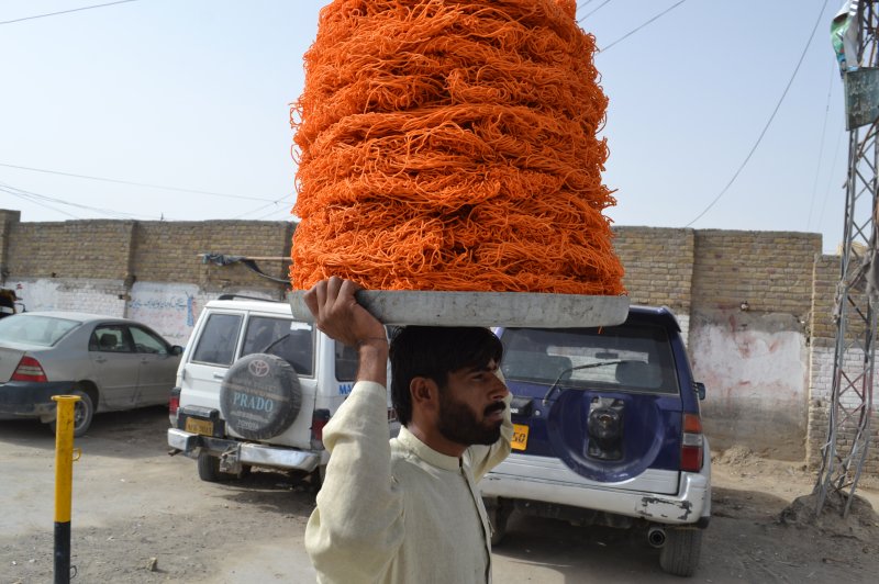 A Pakistani vendor carries sweets to the market for customers shopping during the holy fasting month of Ramadan in Chaman on August 8, 2013. Muslims across the world are observing holy month of Ramadan which prohibits eating, and drinking from dawn to dusk. A heat wave in Karachi has claimed more than 600 lives so far. File photo by Matiullah/UPI Next
