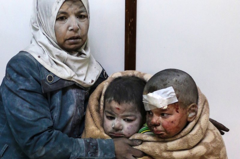 An injured woman holds injured children at a hospital after airstrikes hit areas inhabited by civilians in Barzeh, near Damascus, on February 20. Children in Syria are suffering from the "toxic stress" of constant violence. Photo by Sarieh Abu Zaid/EPA
