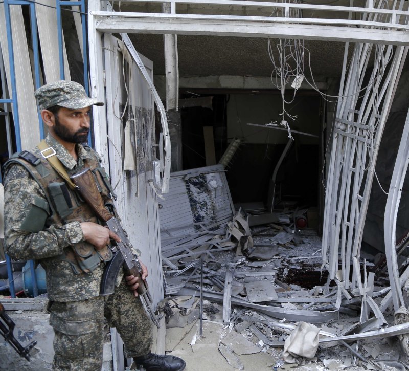 An Afghan soldier guards a bank in Kabul after a suicide bombing killed five people and injured another nine on Tuesday. Photo by Hedayatullah Amid/EPA