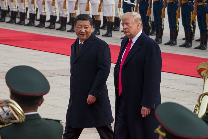 U.S. President Donald J. Trump (C-R) and Chinese President Xi Jinping (C-L) review soldiers of the Chinese People's Liberation Army honor guard during a welcome ceremony at the Great Hall of the People in Beijing, China, in November. On Tuesday, China announced it will cut the import duty on passenger cars. Photo by Roman Pilipey/EPA