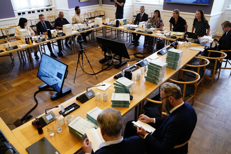 Members of the Committee of Inquiry receive the report produced by the so-called "Mink Commission" at the Danish Parliament in Copenhagen, Denmark, on Thursday. Photo by Mads Claus Rasmussen/EPA-EFE