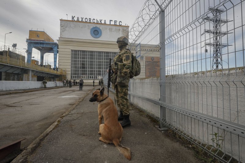 A Russian serviceman and a dog standing guard near the Kakhovka Hydroelectric Power Plant on the Dnieper River in Kakhovka, near Kherson, Ukraine, on May 20. Russian-installed officials called for the evacuation of the region on Friday. File Photo by Sergei Ilnitsky/EPA-EFE