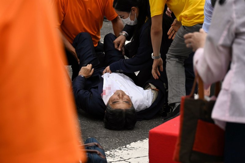 Former Japanese Prime Minister Shinzo Abe lies on the ground Friday after he was shot twice during a campaign speech at the Yamato-Saidaiji Station in Nara, Japan. He died later at a hospital. Photo by Asahi Shimbun/EPA-EFE