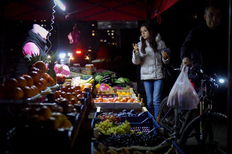 A street market is lit by flashlight in Kyiv, Ukraine, on Thursday, where scheduled power cuts were introduced all over the country as Russians continue attacks on Ukrainian energy infrastructure. Photo by Oleg Petrasyuk/EPA-EFE