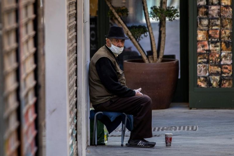 A man sits on a street corner Wednesday in Seville, Spain, in a nation that's so far reported more than 24,500 coronavirus deaths. Photo by Julio Munoz/EPA-EFE