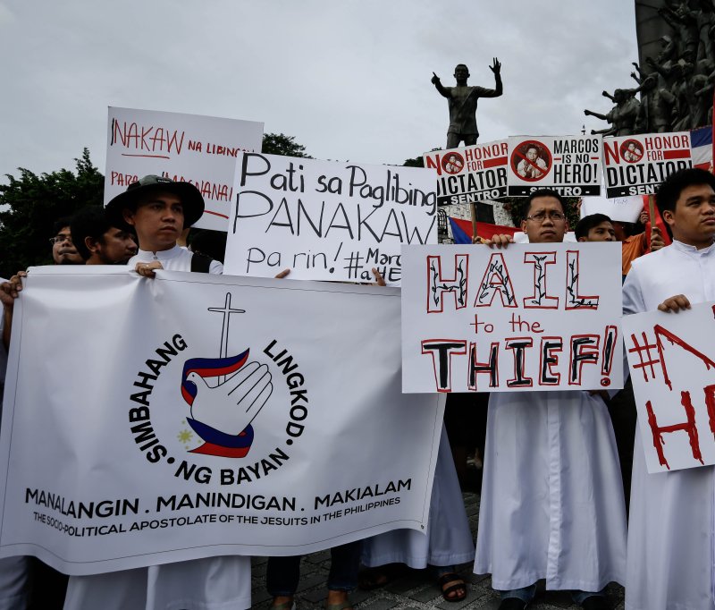 Filipino priests hold placards during a protest against the burial of former dictator Ferdinand Marcos at the People Power Monument in Quezon City, northeast of Manila on November 18, 2016. On September 28, 1989, Marcos died in exile in Hawaii. File Photo by Mark R. Cristino/EPA