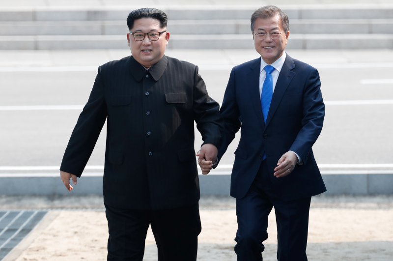 South Korean President Moon Jae-in (R) and North Korean leader Kim Jong-un hold hands while walking at the military demarcation line Friday at the Joint Security Area on the Demilitarized Zone in the border village of Panmunjom in Paju, South Korea. It was the first time a North Korean leader has crossed the border since the Korean War. Photo by Korea Summit Press Pool/EPA-EFE