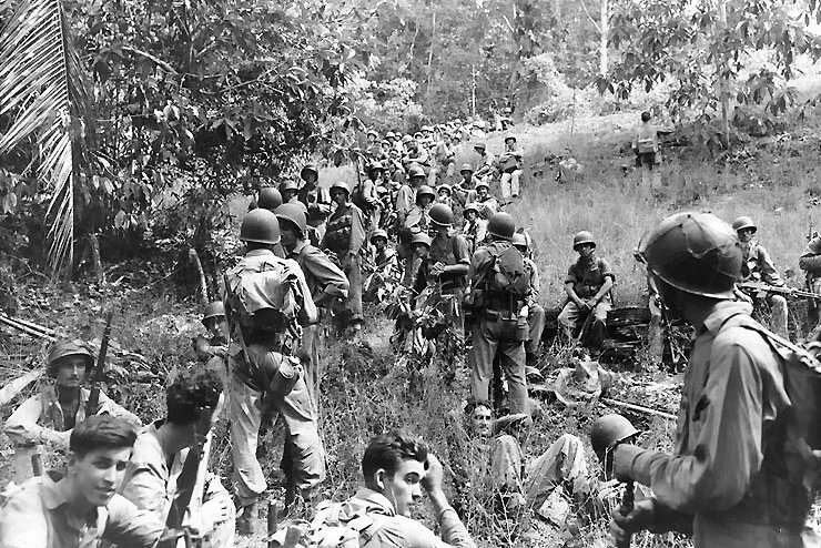Troops from the U.S. Army's 164th Infantry rest at Guadalcanal, Solomon Islands, in November 1942. On February 9, 1943, in a major World War II strategic victory, the Allies retook Guadalcanal in the Solomon Islands from the Japanese. File Photo courtesy the U.S. Navy.