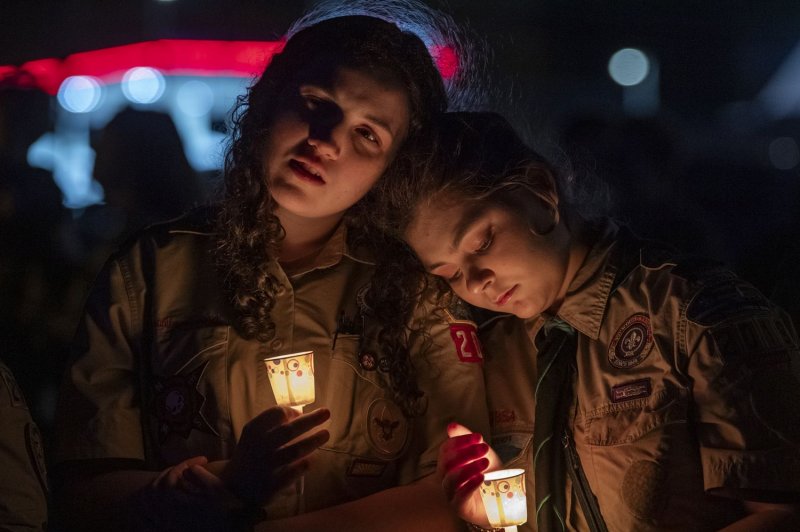 Members of the Maine Boys Scouts of America embrace during a a candlelight vigil for the the victims of the Lewiston shooting at the Worumbo Riverfront in Lisbon, Maine, on October 28. Autopsy results Friday indicated main suspect Robert Card was alive during much of the two-day manhunt for him. File Photo by Amanda Sagba/EPA-EFE