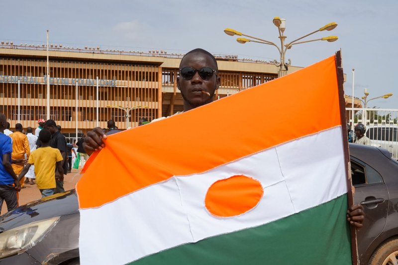 A man displays a Niger flag on his way to a rally in a stadium in Niamey, Niger, on Sunday. Thousands of pro-junta supporters gathered in a stadium to show their support for the military coup ahead of the deadline given by the Economic Community of West African States to free and reinstate democratically elected President Mohamed Bazoum. Photo by Issifou Djibo/EPA-EFE