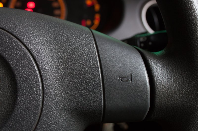Close up of a steering wheel with a horn symbol. Photo by anuje/Shutterstock