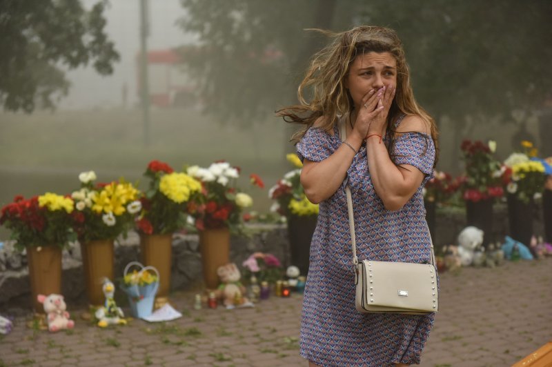 A Ukrainian woman sobs near flowers placed near the site of the destroyed shopping mall in Kremenchuk, Ukraine, on Tuesday. At least 20 people were killed by the rocket strike. Photo by Oleg Petrasyuk/EPA-EFE