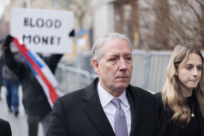 Charles McGonigal, a former counterintelligence chief for the FBI, leaves a federal courthouse as a protestor carries a sign and a Russian flag behind him after a hearing related to his arrest in New York in February. File Photo by Justin Lane/EPA-EFE