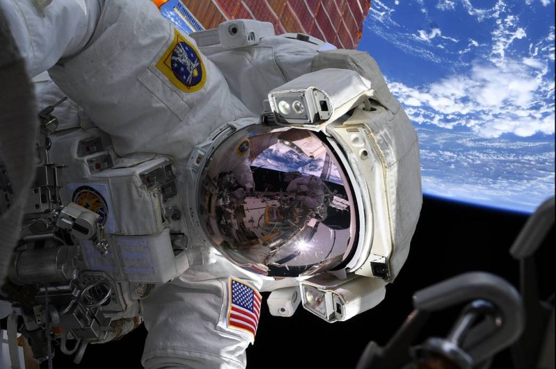 NASA Astronaut Christina Koch on Oct. 7 worked with Astronaut Drew Morgan outside the International Space Station. Exposure to microgravity changes expression of genes in heart cells grown in space, a new study found. File Photo by Christina Koch/NASA