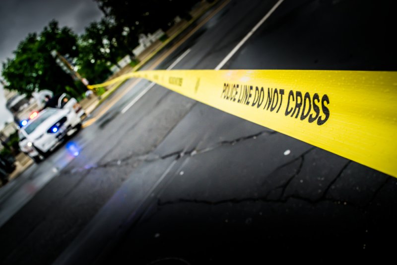 Close up crime scene investigation police boundary tape. Photo by Miki Sarabiez/Shutterstock