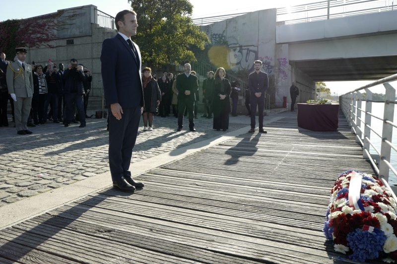 French President Emmanuel Macron stands at attention after laying a wreath near the Pont de de Bezons in Colombes on Saturday. Photo by Rafael Yaghobzadeh/EPA-EFE