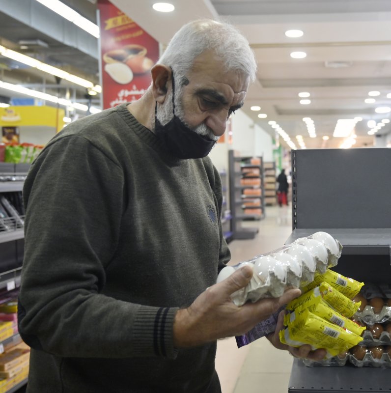 A shopper examines egg prices in a supermarket in Beirut, Lebanon. Many people are struggling to cover basic needs as food prices soar. Photo by Wael Hamzeh/EPA-EFE