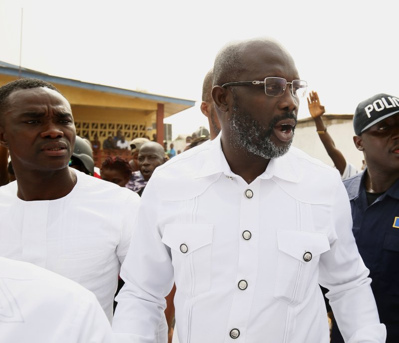 Liberians celebrated in the capital of Monrovia after George Weah (C) secured enough votes to become president. Photo by Ahmed Jallanzo/EPA-EFE
