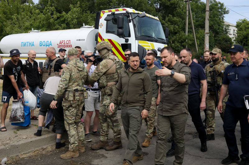 Ukrainian President Volodymyr Zelensky (C) speaks to National Police Chief Ihor Klymenko (R) during a visit Thursday to Kherson to assess the damage from flooding unleashed by the destruction of the Kakhovka hydroelectric dam earlier in the week. Photo by Mykola Tymchenko/EPA-EFE