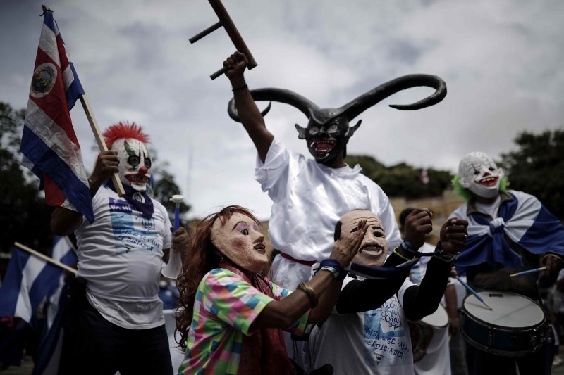 Two people with masks that represent Nicaraguan President Daniel Ortega, and his wife, Vice President Rosario Murillo, in handcuffs, during a protest through the main streets of San Jose, Costa Rica, against the presidential elections in their country of Nicaragua on November 7. On Monday, the United States, Canada and Britain sanction government officials over the election they say was rigged. Photo by Jeffrey Arguedas/EPA-EFE
