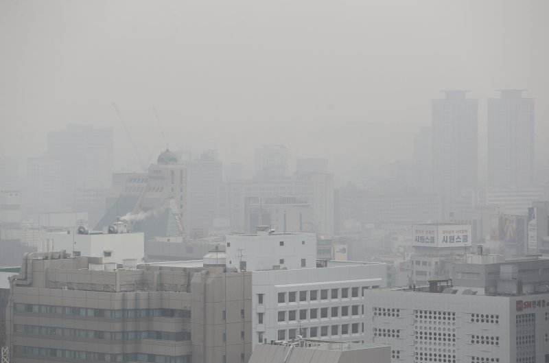 Smog covers buildings in downtown Seoul, South Korea, on Feb. 23 from fine dust as the temperatures warmed. Officials said the ultrafine dust level rose as locally emitted fine dust added to those that came from outside the country. Photo by Yonhap.