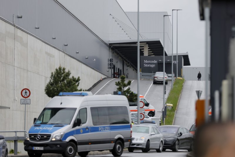A police car is parked in front of the Mercedes-Benz factory where a fatal shooting took place in Sindelfingen, Germany, on Thursday. Photo by Ronald Wittek/EPA-EFE