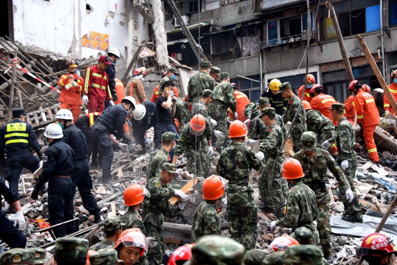 A picture released on October 11, 2016, shows rescuers searching for victims on the site of collapsed residential buildings in Wenzhou, Zhejiang province, China. According to media reports, 22 people were found dead in the debris. The cause of the collapse, which occurred on October 10, is unknown. Photo by Zhang Xinlei/epa