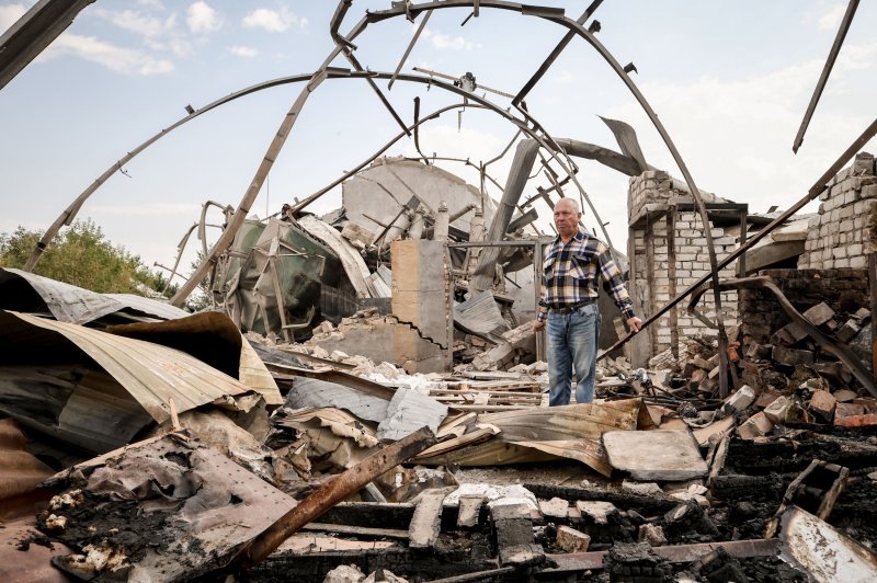 Ukrainian farmer Yakiv Marynchenko, 67, inspects the rubble of a destroyed grain storage on his farm, near the frontline town of Orikhiv, Zaporizhzhia region, on Thursday. Marynchenko, who has owned the farm since 1995, cultivates sunflowers, wheat and other grains. He also owned a mill, but it was destroyed when Russian shelling hit his farm at the end of August. Photo by Kateryna Klochko/EPA-EFE