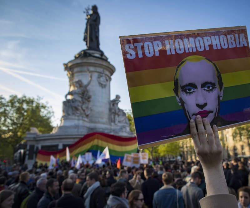 A demonstrator holders a placard depicting Russian President Vladimir Putin with the label "Stop Homophobia," to denounce the anti-gay campaign launched in the Russian province of Chechnya, during a protest in Paris. Activists said five countries thus far have offered to help resettle the men outside Russia. Photo by IAN LANGSDON/EPA
