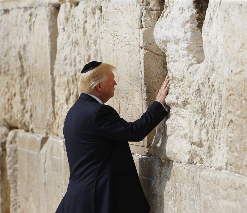 President Donald Trump touches the Western Wall in Jerusalem's Old City on May 22. On Wednesday, Israel’s transportation minister said a new train station would be named after the U.S. president. File Photo by Ronen Zvulun/EPA