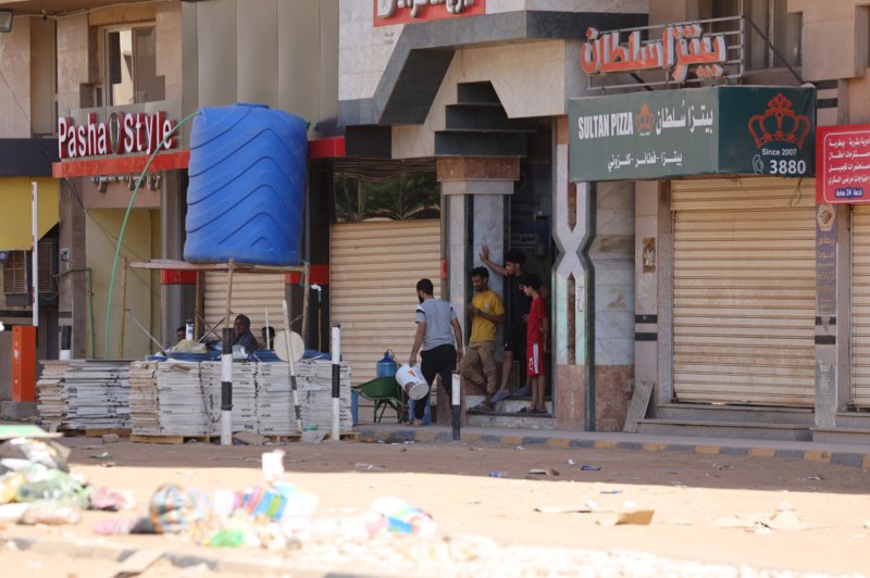 Sudanese people stand in front of a shop in Khartoum, Sudan, on April 19. Talks between warring Sudanese military factions began Saturday in Saudi Arabia. File Photo by EPA-EFE