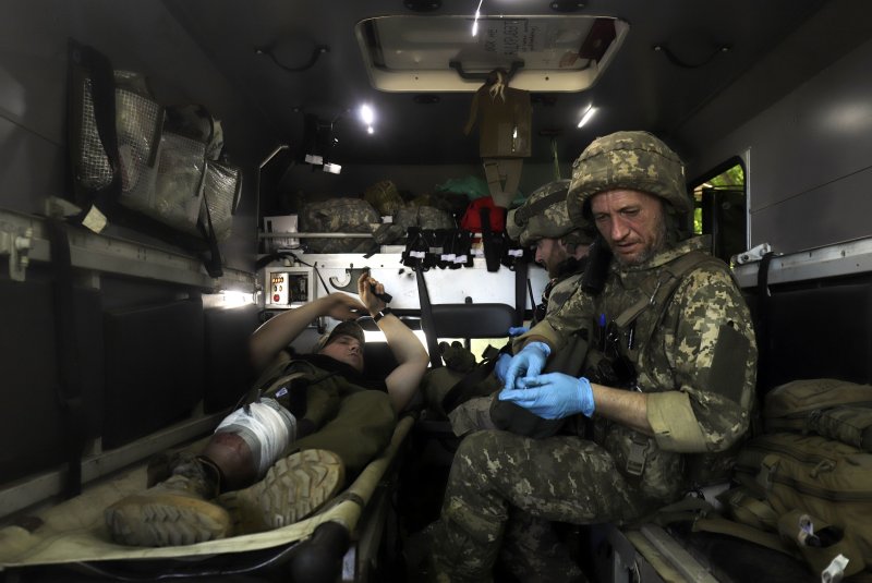 A military medic gives first aid to an injured Ukrainian serviceman close to a front line near the small city of Svitlodarsk, Donetsk oblast, on Friday amid heavy fighting in that region in the last days. File Photo by STR/EPA-EFE