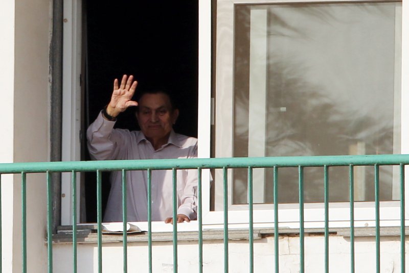 Former Egyptian President Hosni Mubarak waves to supporters from his room during the celebrations of the 43rd anniversary of the 1973 Arab-Israeli war on October 6 outside of Maadi Military Hospital, where he stayed while under detention in Cairo. Egyptian prosecutors freed Mubarak on Monday, state-run media reported. File Photo by Khaled Elfiqi/EPA