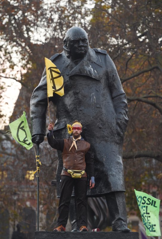 A pro-environment protester stands on the statue of former British Prime Minister and WWII leader Winston Churchill in London, Britain, Saturday. The protest organized by the Extinction Rebellion group shut down five main bridges across the river Thames, seeking to bring attention to political inaction on issues of pollution and climate change. Photo by Facundo Arrizabalaga/EPA-EFE