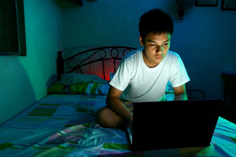 Looking at the LED light in the screens of mobile devices at night may increase a person's blood sugar and desire to eat sugar the next day. File Photo by junpinzon/Shutterstock