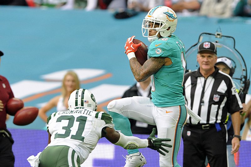 Miami Dolphins wide receiver Kenny Stills (R) scores a touchdown against the New York Jets with Antonio Cromartie (L) during their NFL International series match at Wembley Stadium, London, Britain, 04 October 2015. EPA/GERRY PENNY
