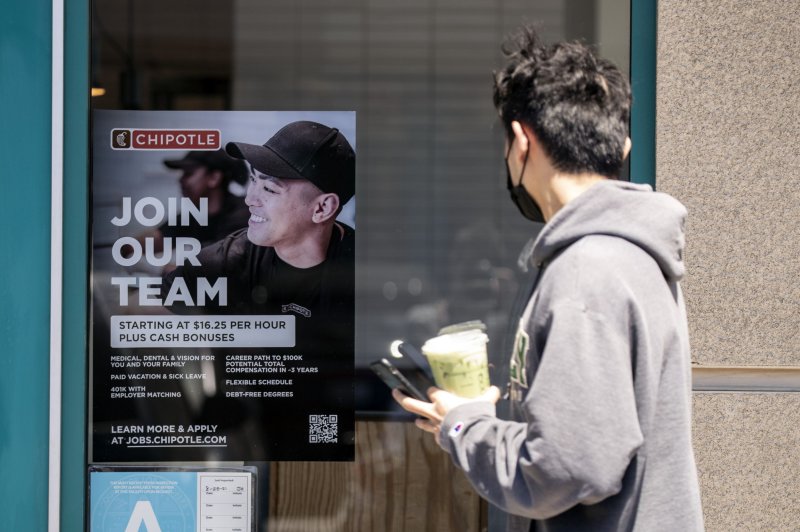A man looks at a hiring sign reading 'Join our team' displayed on a Chipotle restaurant window in a strip mall in Los Angeles, California on May 11, 2022. The Labor Department said on Thursday that workers filing for unemployment claims for the first time dropped to its lowest level in a month. File Photo by Etienne Laurent/EPA-EFE
